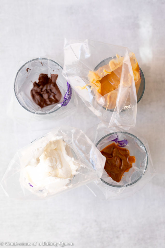 whipped cream, chocolate, dulce de leche, and pastry cream all in piping bags in glasses