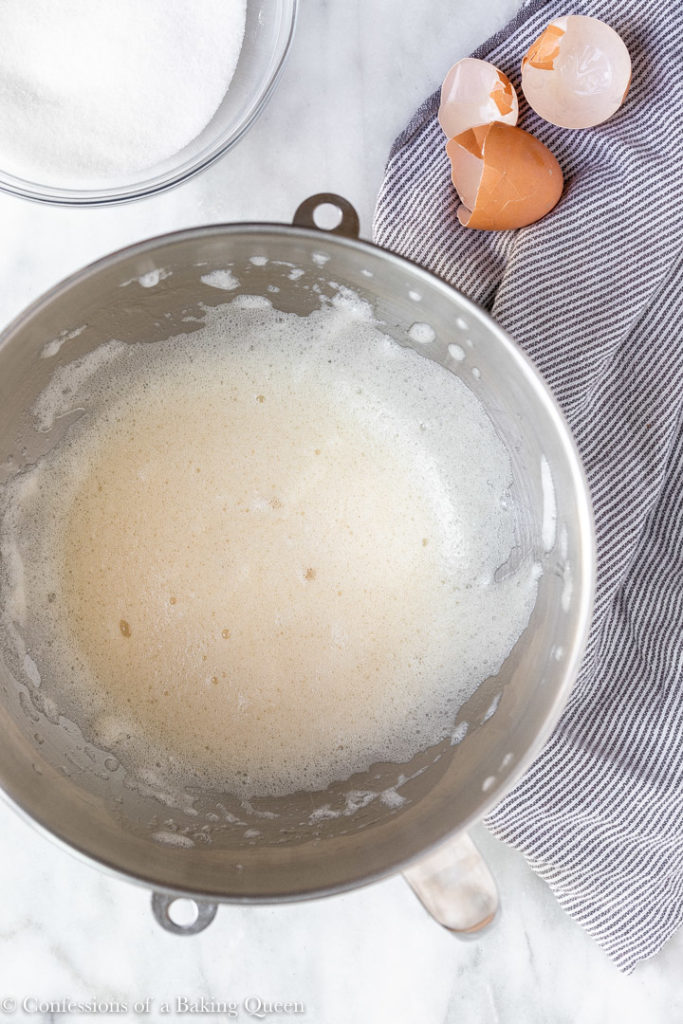 foamy egg whites in a metal mixing bowl
