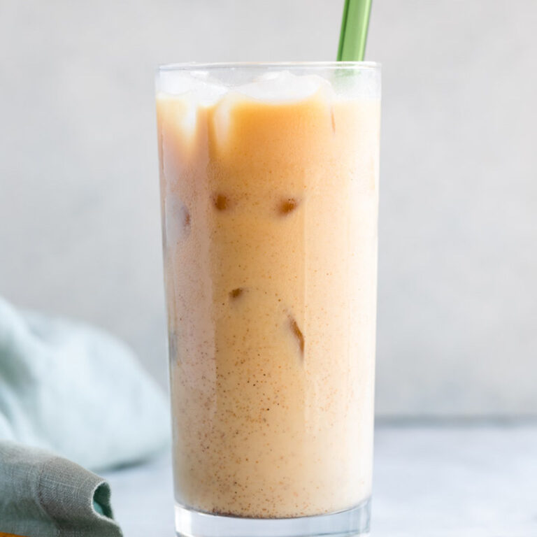 glass of thai iced tea on a white counter
