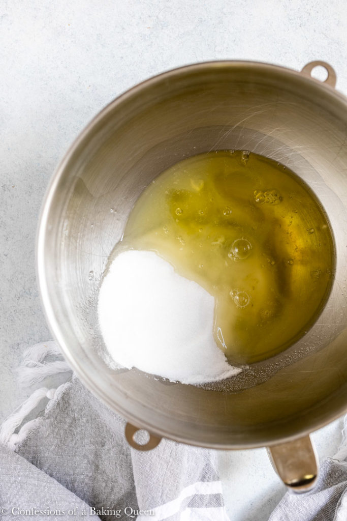 granulated sugar and egg whites in a metal mixing bowl