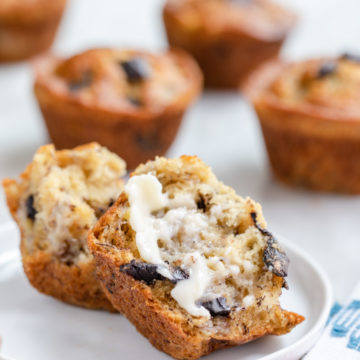 banana chocolate chip muffin pieces with butter on served on a small round plate
