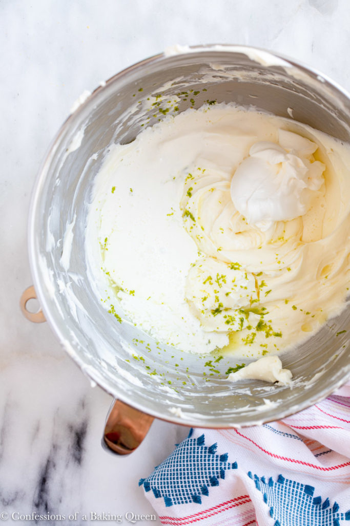 key lime zest and juice, sour cream and heavy cream added to cheesecake mixture in a large metal mixing bowl