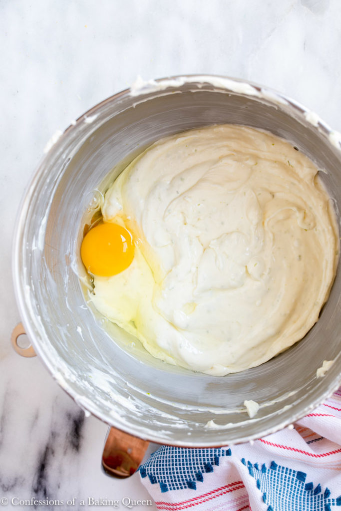 large egg added to key lime cheesecake batter in a large mixing bowl