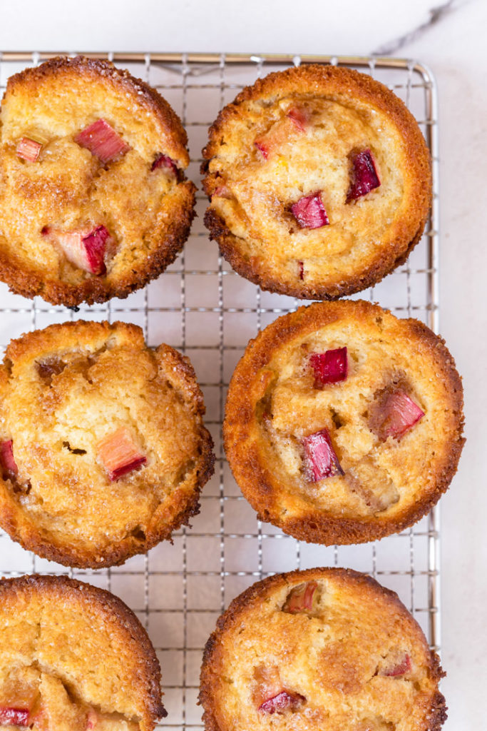 six rhubarb muffins cooling on a wire rack