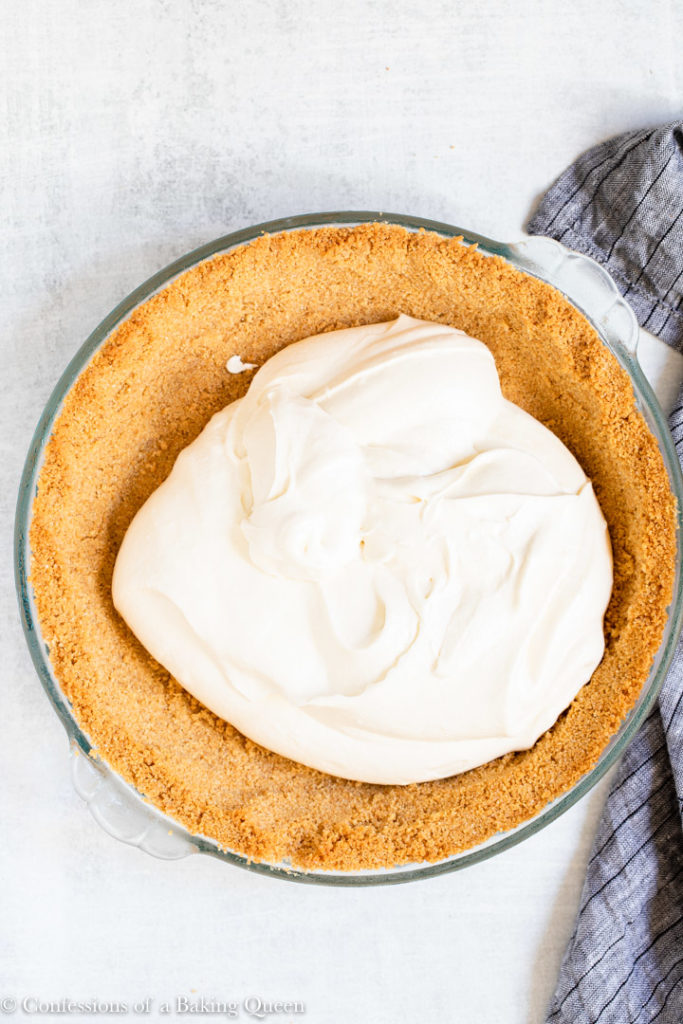 whipped cream cheese mixture in a graham cracker crust
