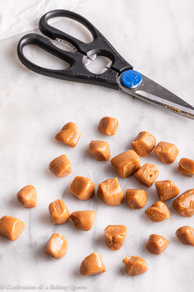 scissors next to cut up chewy caramel pieces