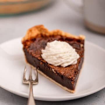slice of chocolate chess pie with whipped cream on a plate