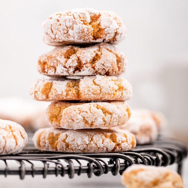five amaretti cookies stacked on a black wire rack