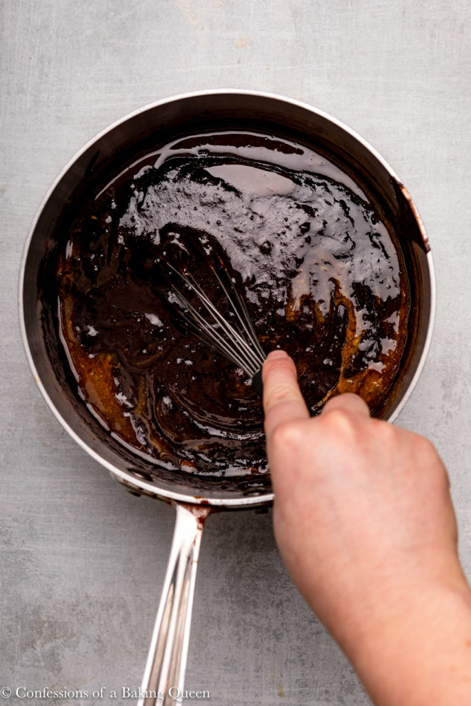 hand holding a whisk mixing brownie batter