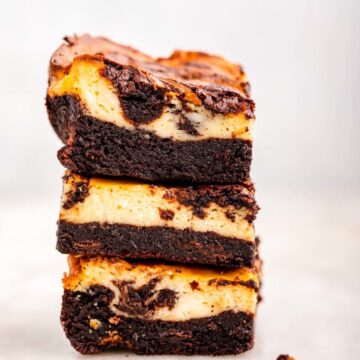 stack of cheesecake brownies on a muted background