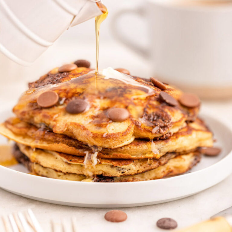 syrup poured on top of a stack of chocolate chip pancakes