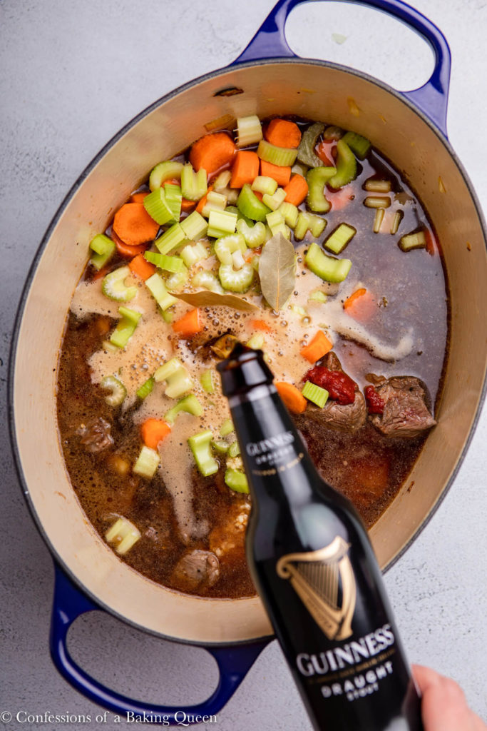 guinness poured into a dutch oven of beef stew ingredients