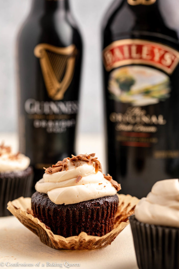 baileys frosted guinness chocolate cupcakes next to a bottle of Guinness and Baileys