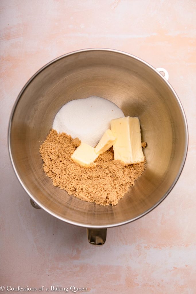 butter and sugars in a metal mixing bowl