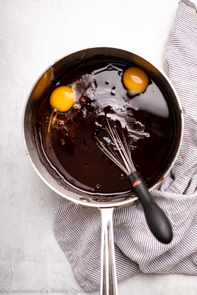 egg and egg yolk added to chocolate mixture in a large pot
