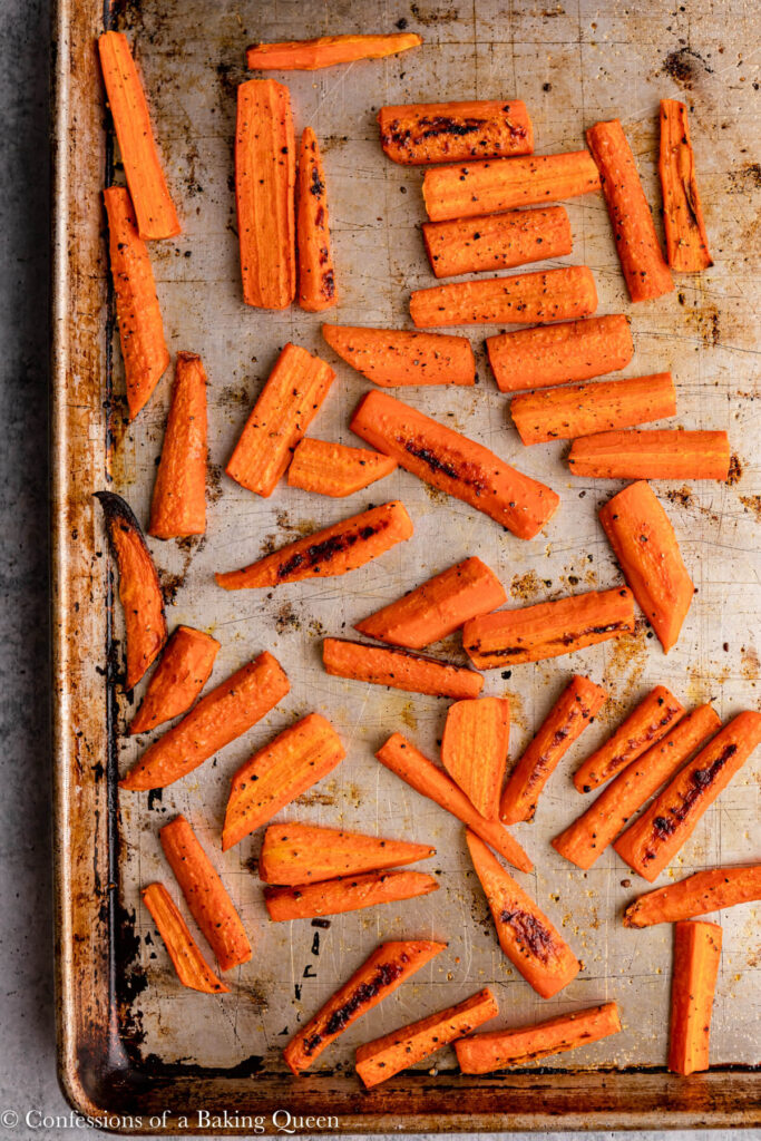 roasted carrots on a sheet pan on a grey surface