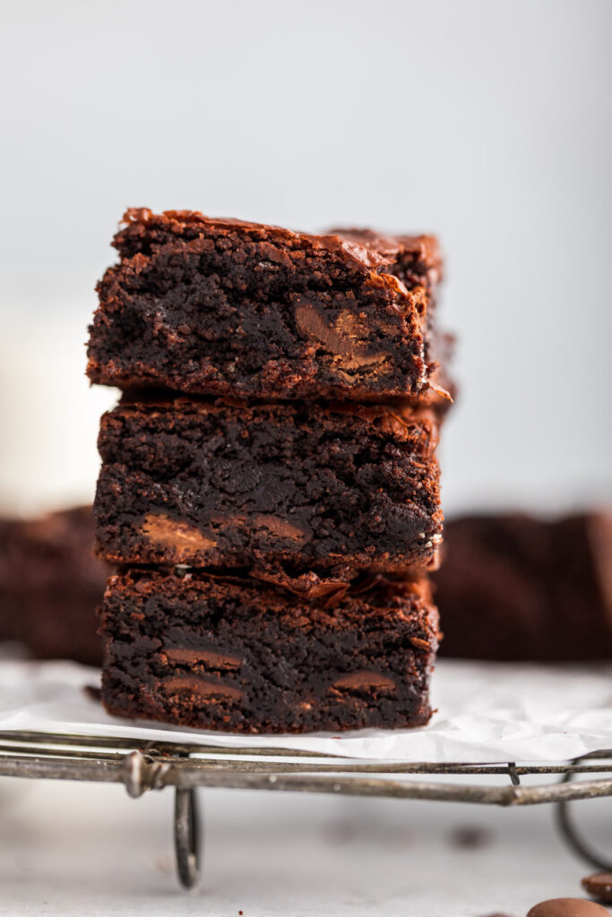 stack of almond flour brownies on a wire rack on a grey surface 