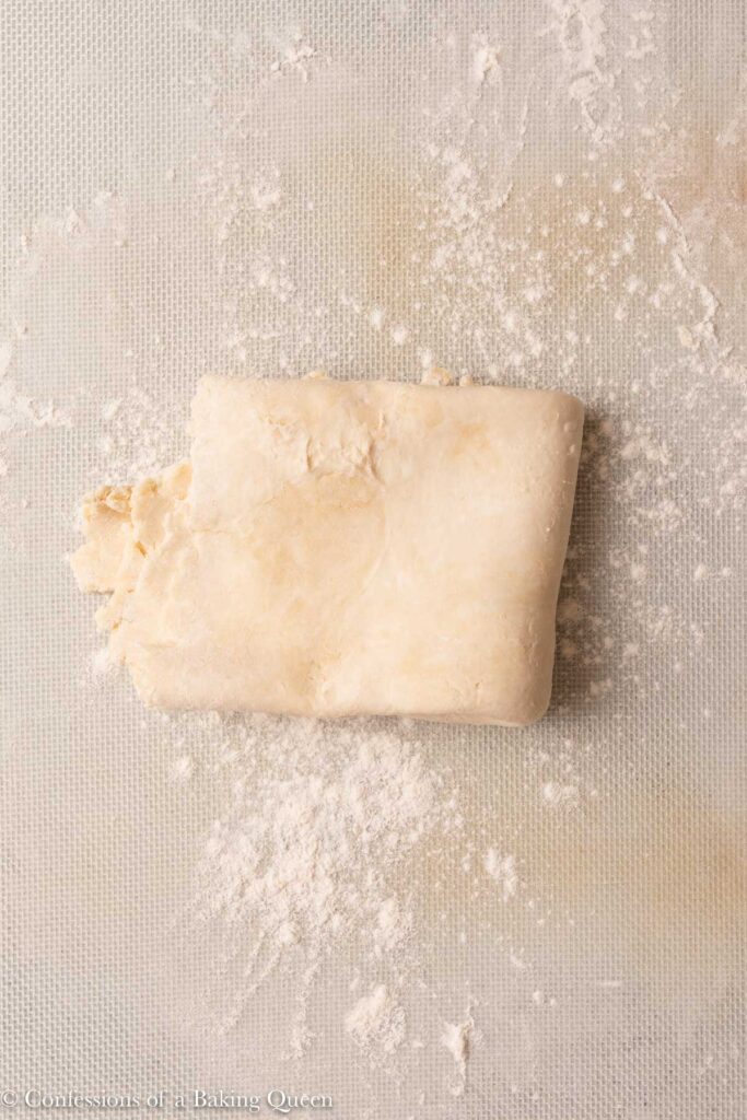 folded up square of pie dough on a lightly floured surface