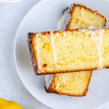 lemon curd loaf slices on a white plate on a light background with lemons