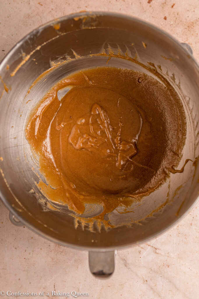wet ingredients for cookie dough in a metal bowl on a light brown surface