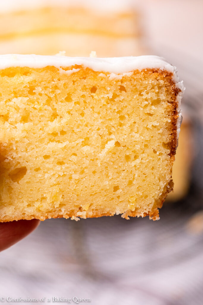 hand holding a piece of lemon cake up to the camera