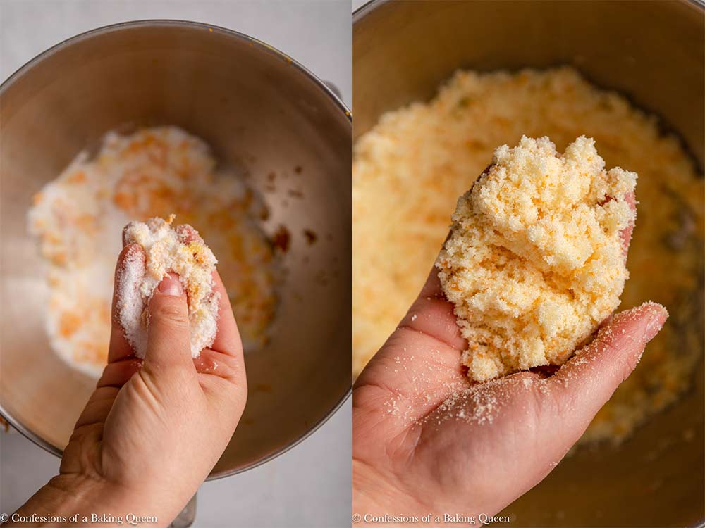 hand rubbing orange zest into sugar over a metal bowl on a light grey surface
