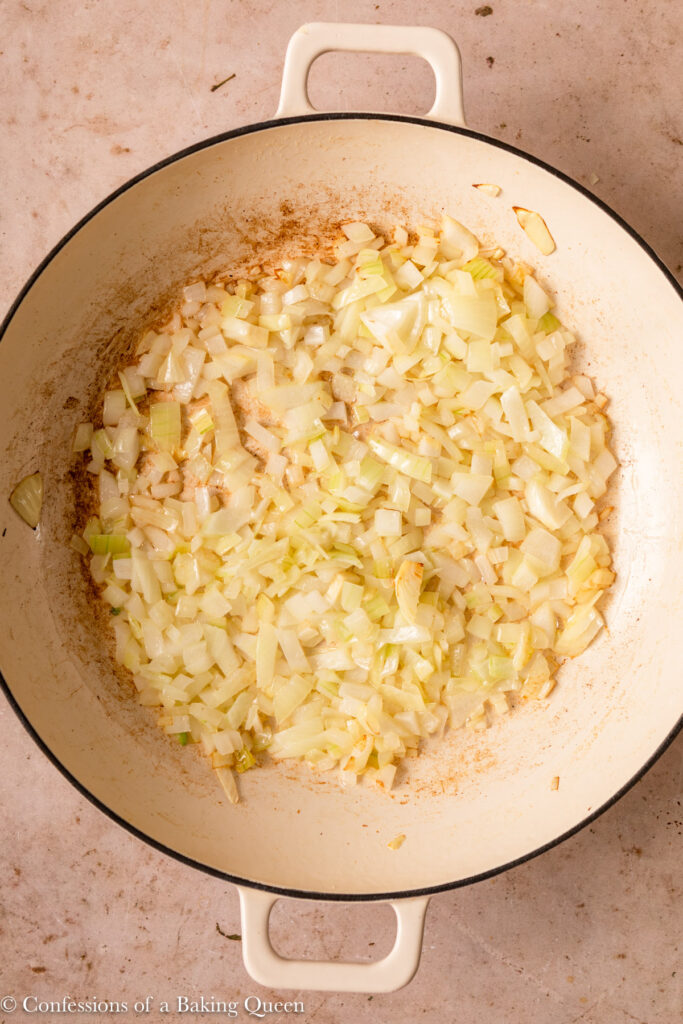 close up of onions sautéed in skillet on a light brown surface