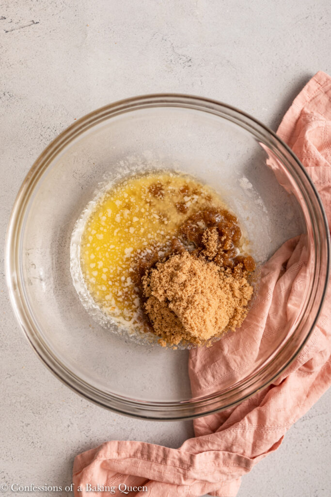 melted butter and brown sugar in a glass bowl on a light grey surface with a pink linen