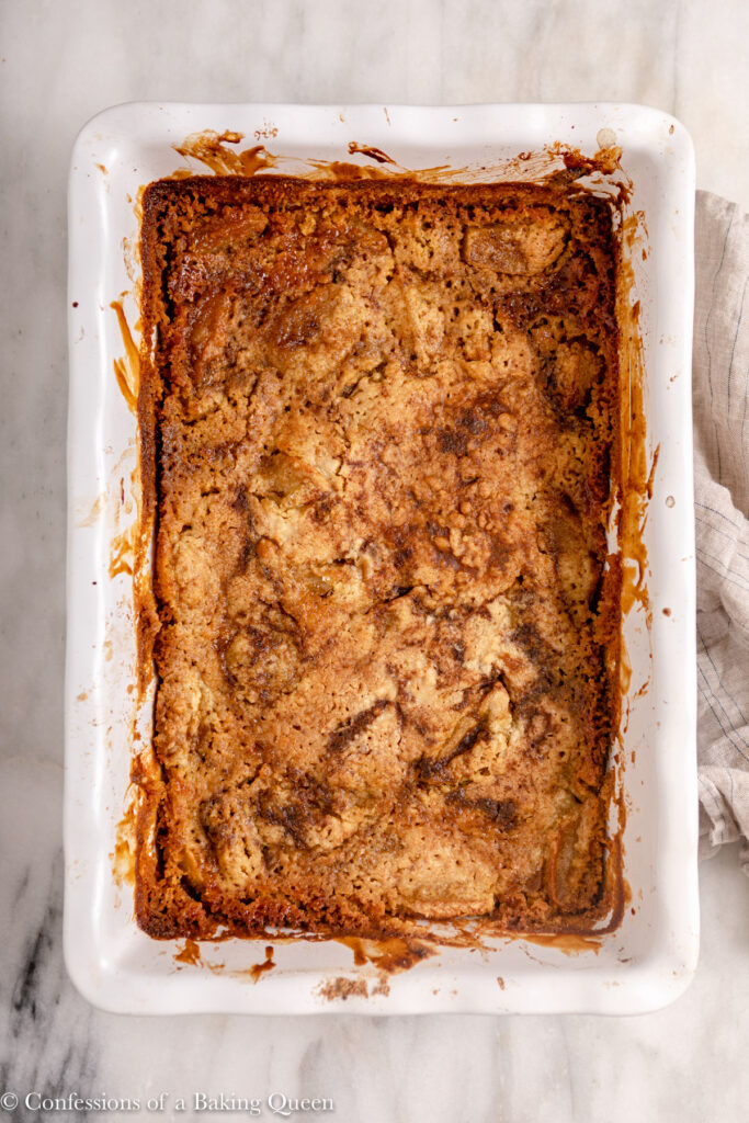 caramel apple dump cake just baked cooling in a dish on a marble counter on a marble surface