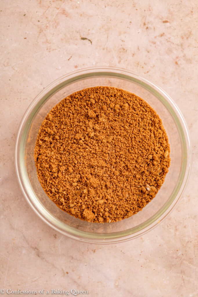 brown sugar and ground cinnamon mixed together in a glass bowl on a light brown surface