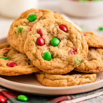 christmas m&m cookies on a pink plate on a christmas napkin
