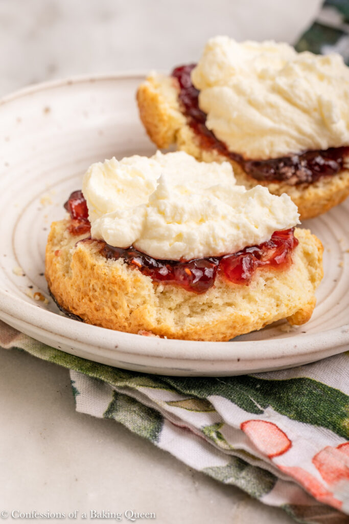 fresh scone with jam and mock clotted cream on a white plate