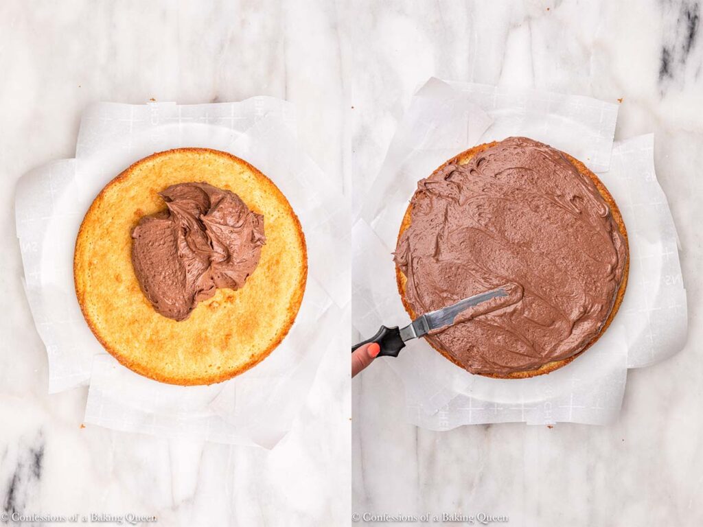 chocolate frosting spread onto yellow cake with a small angled spatula on a white plate on a white marble surface