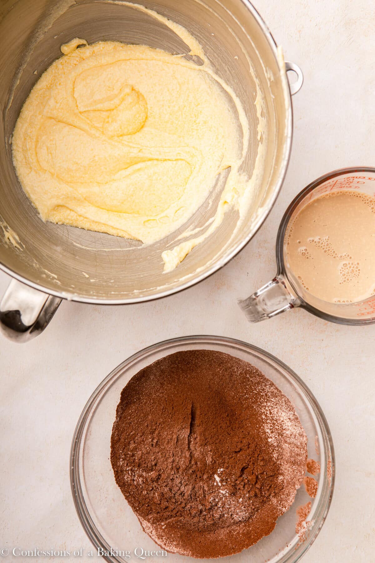 chocolate pound cake batter ingredients in three separate bowls on a light surface