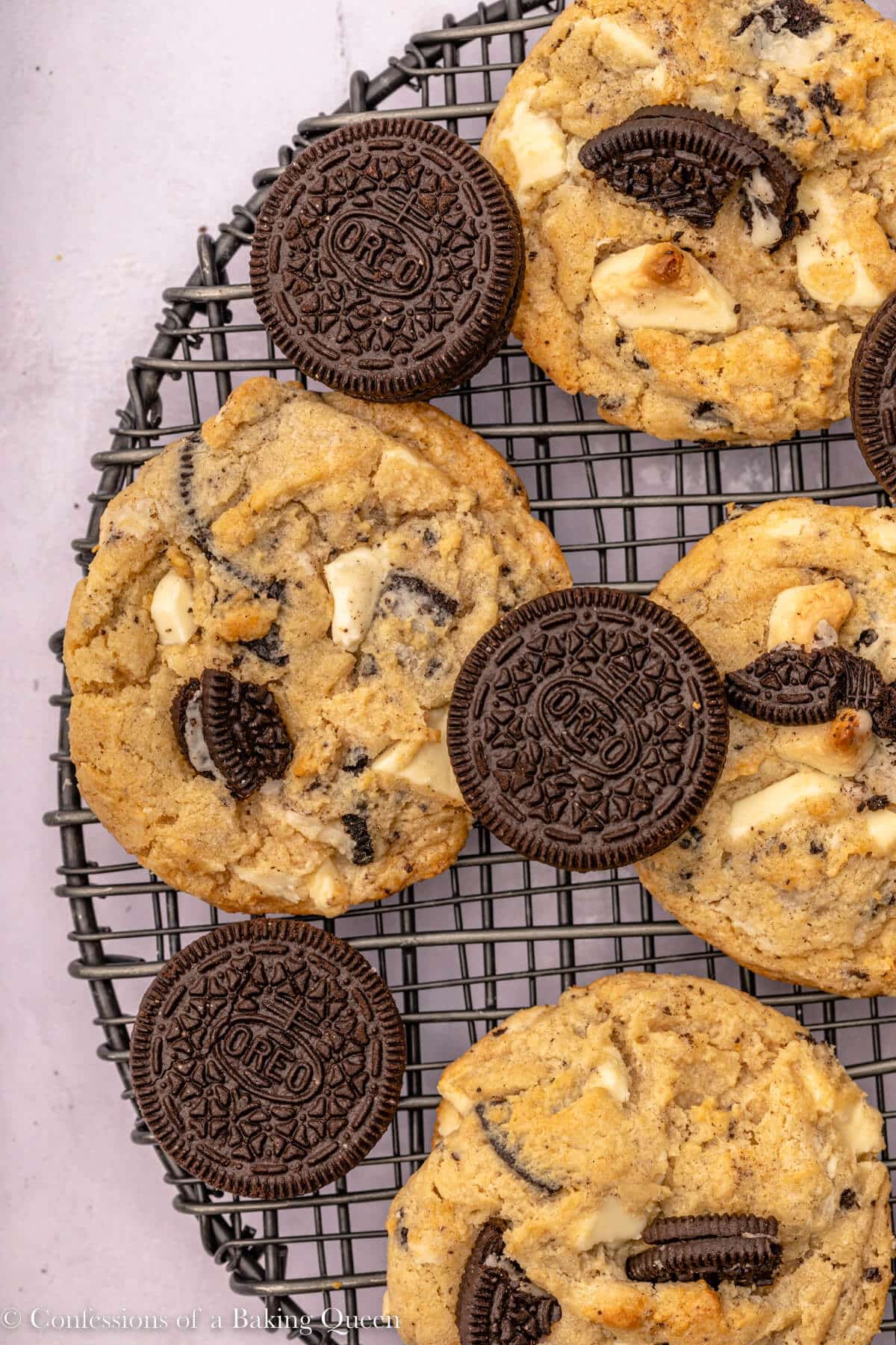 oreo and white chocolate chunk cookies on a wire rack on an light surface