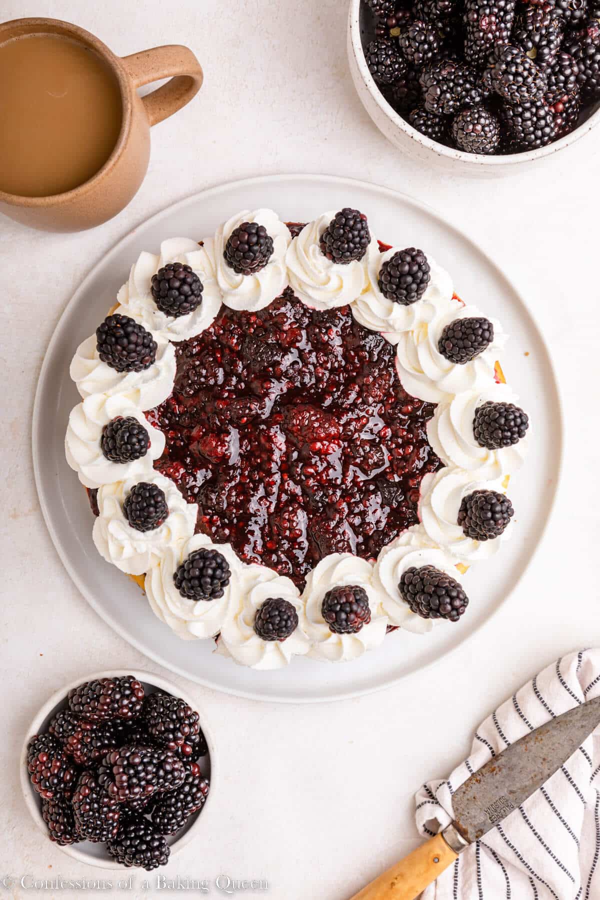 blackberry cheesecake served with coffee and more berries on a light surface