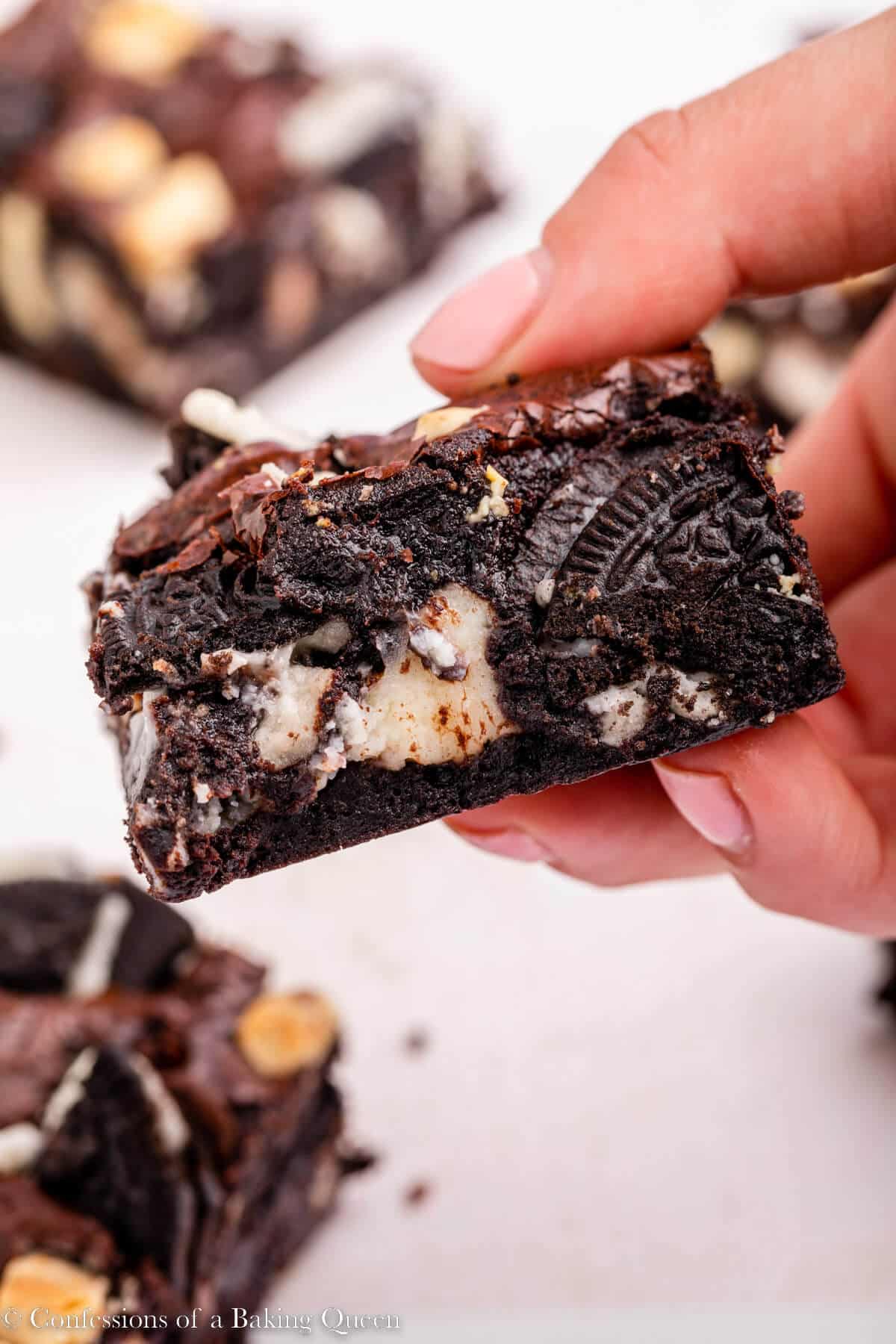 hand holding a cookies and cream brownie up to the camera