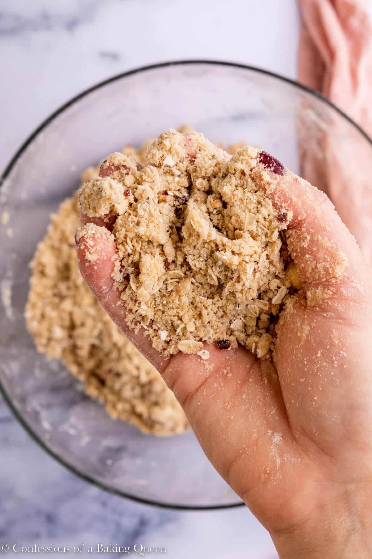 hand holding crumble ingredients up to the camera