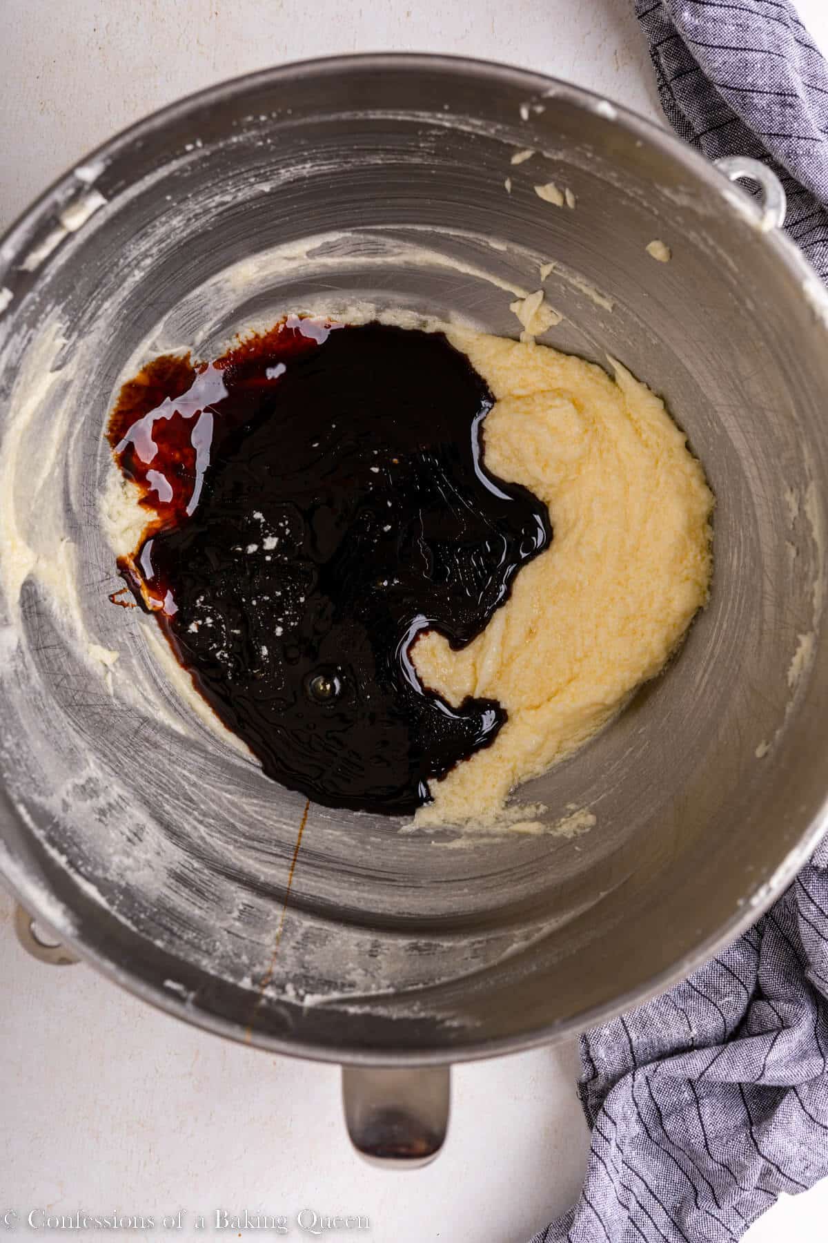 molasses added to wet ingredients in a metal bowl on alight surface with a blue linen