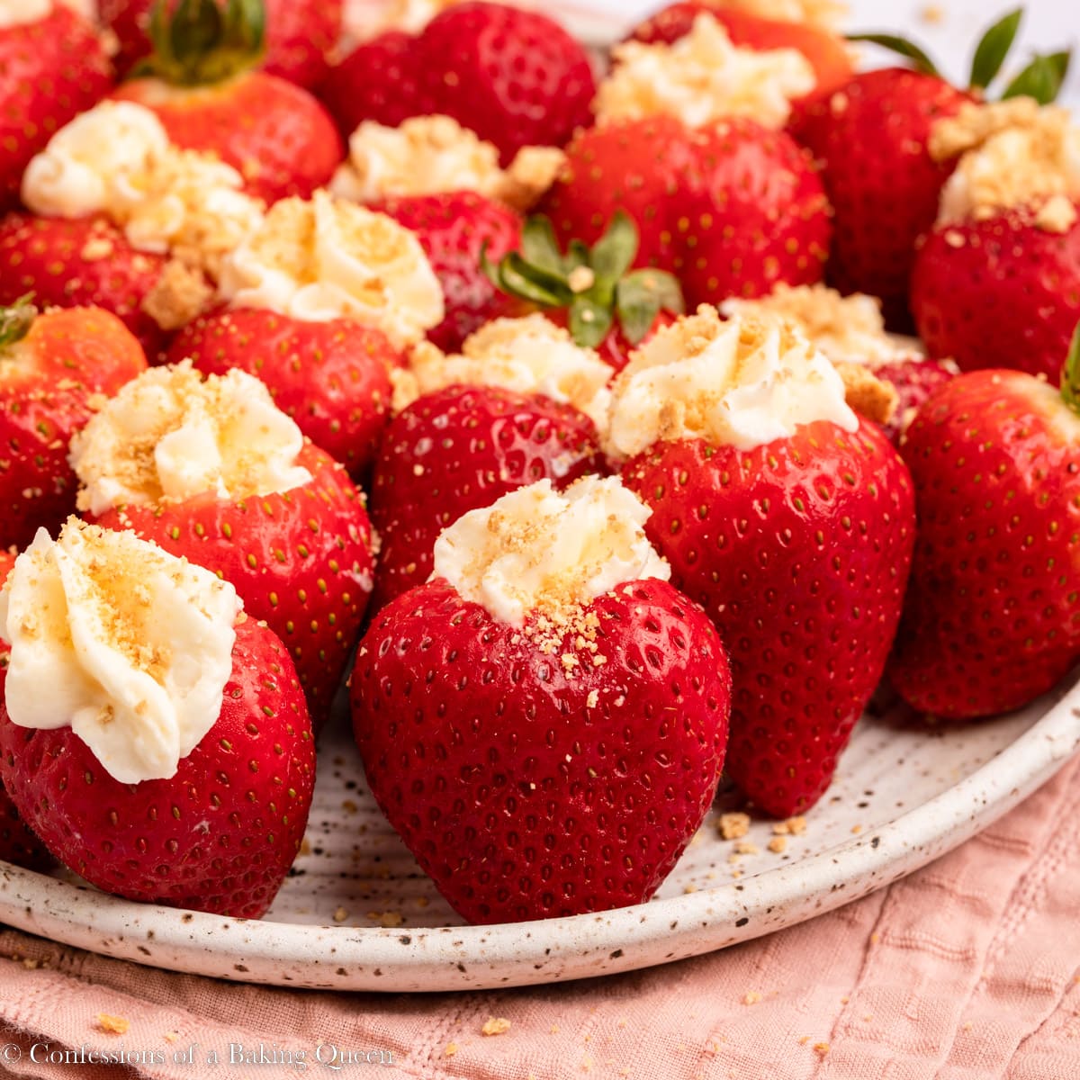 Cheesecake stuffed strawberries arranged on a plate.