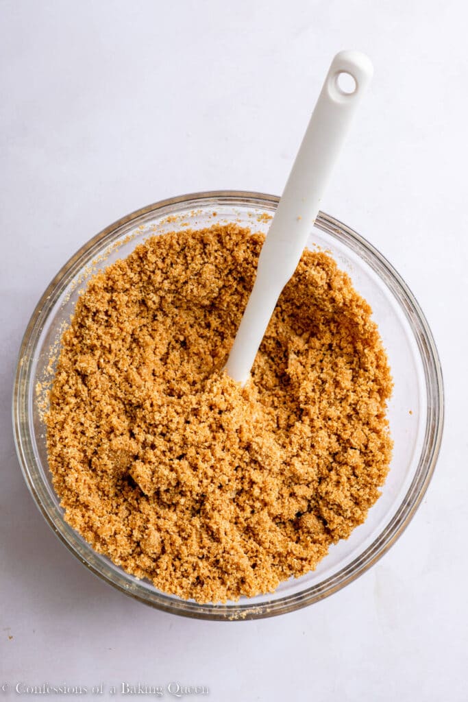 graham cracker crust crumbs in a small glass bowl with a white spatula