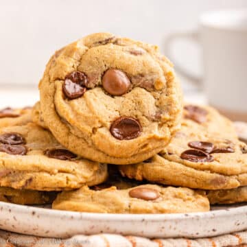 cream cheese chocolate chip cookies on a plate on top of an orange and white linen on a light surface