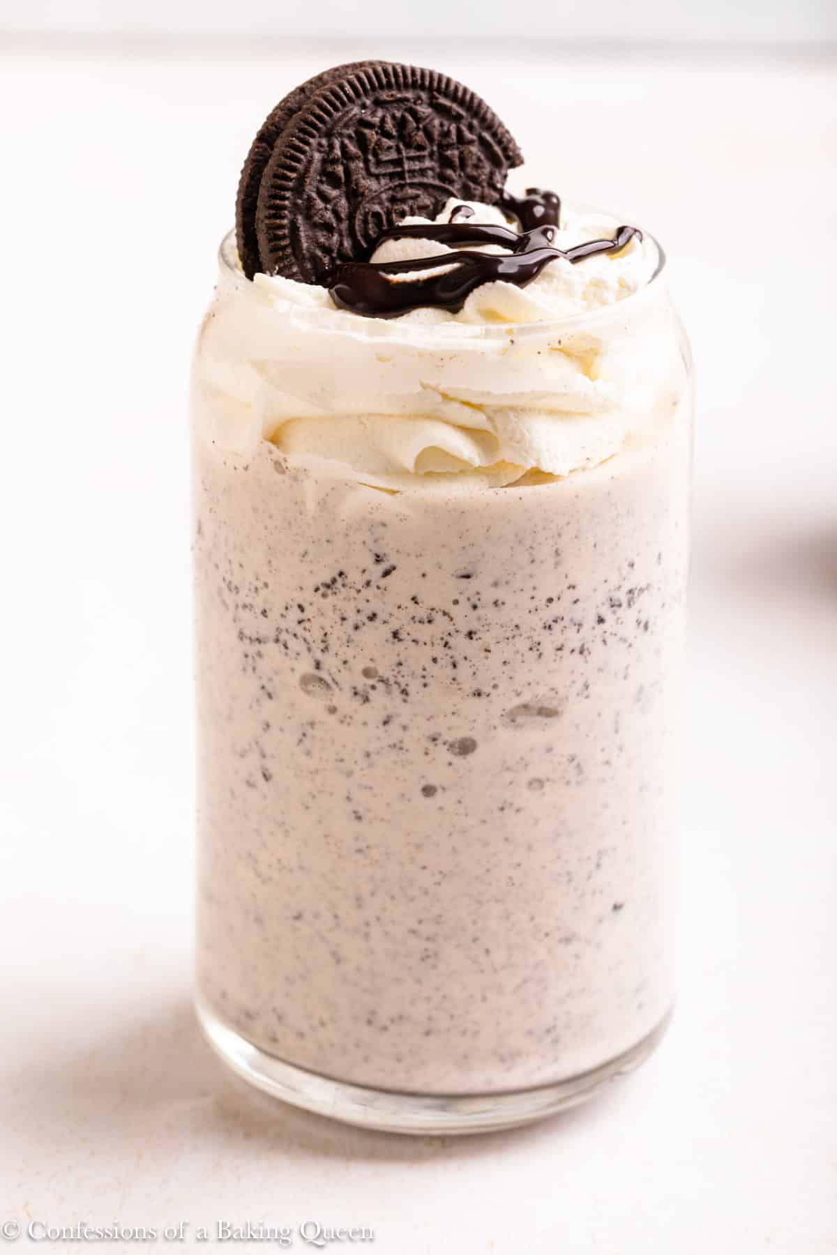 An Oreo milkshake topped with whipped cream and an Oreo.