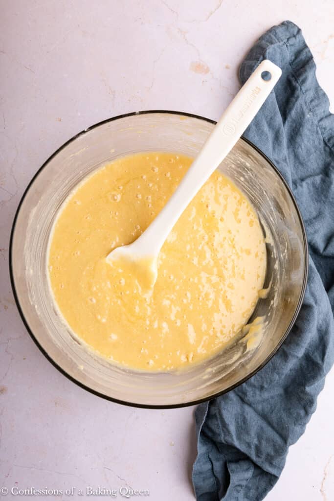 Almond cake batter in a mixing bowl with a rubber spatula.
