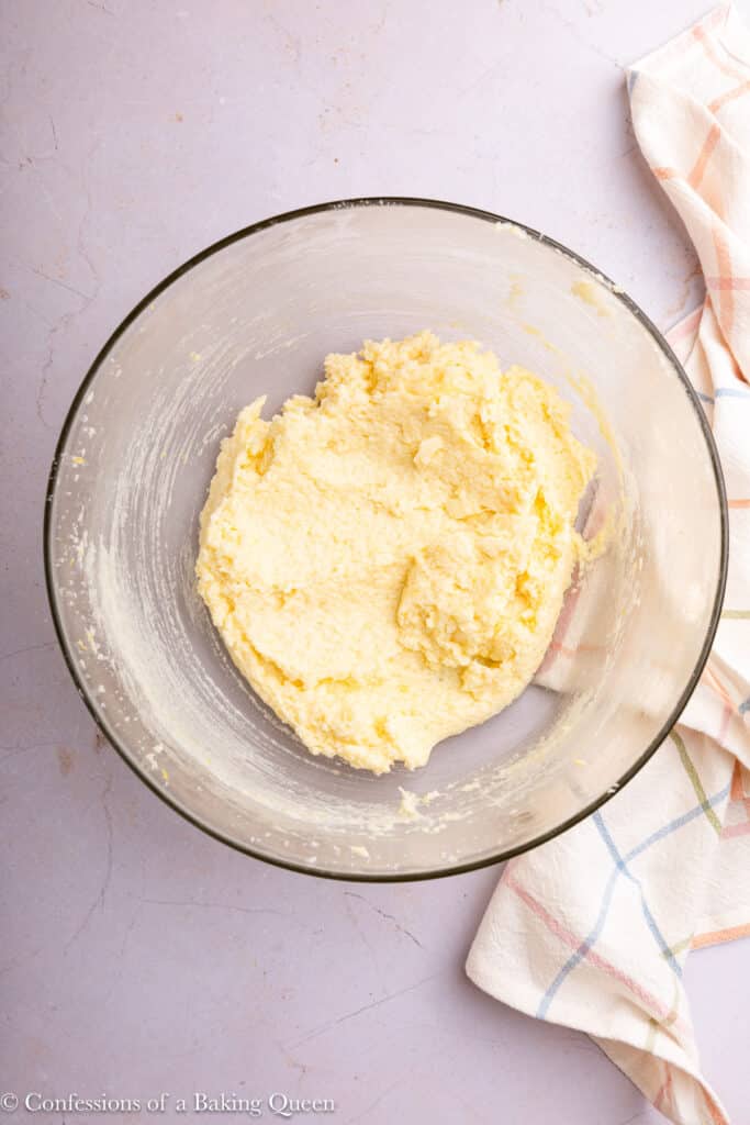 Sugar, butter, and lemon zest creamed together in a mixing bowl.