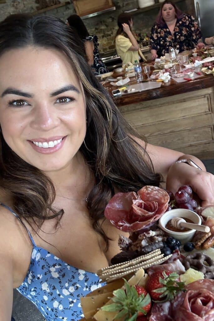 elizabeth waterson holding a charcuterie board up to the camera