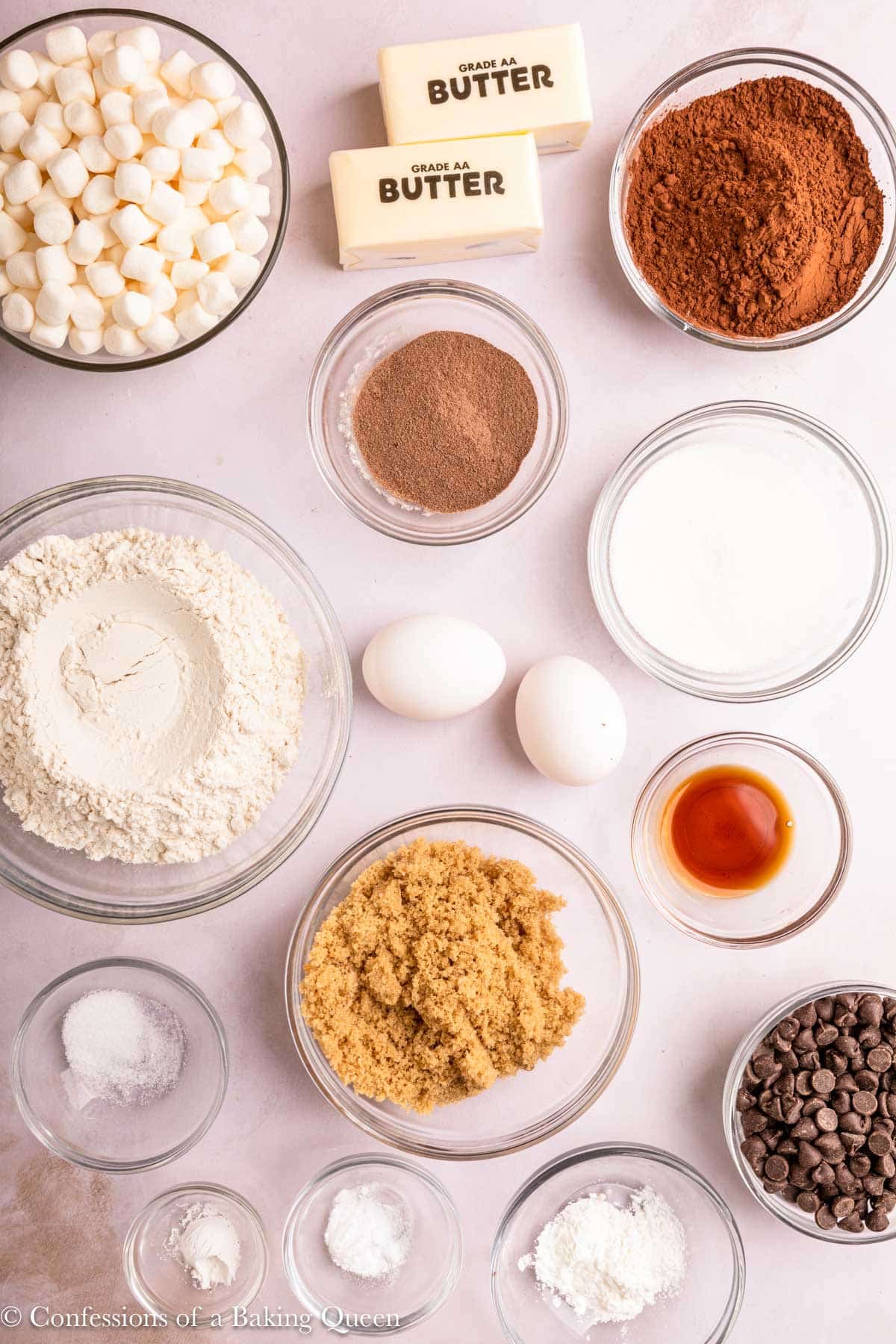 ingredients for hot chocolate cookies in small bowls on a light surface