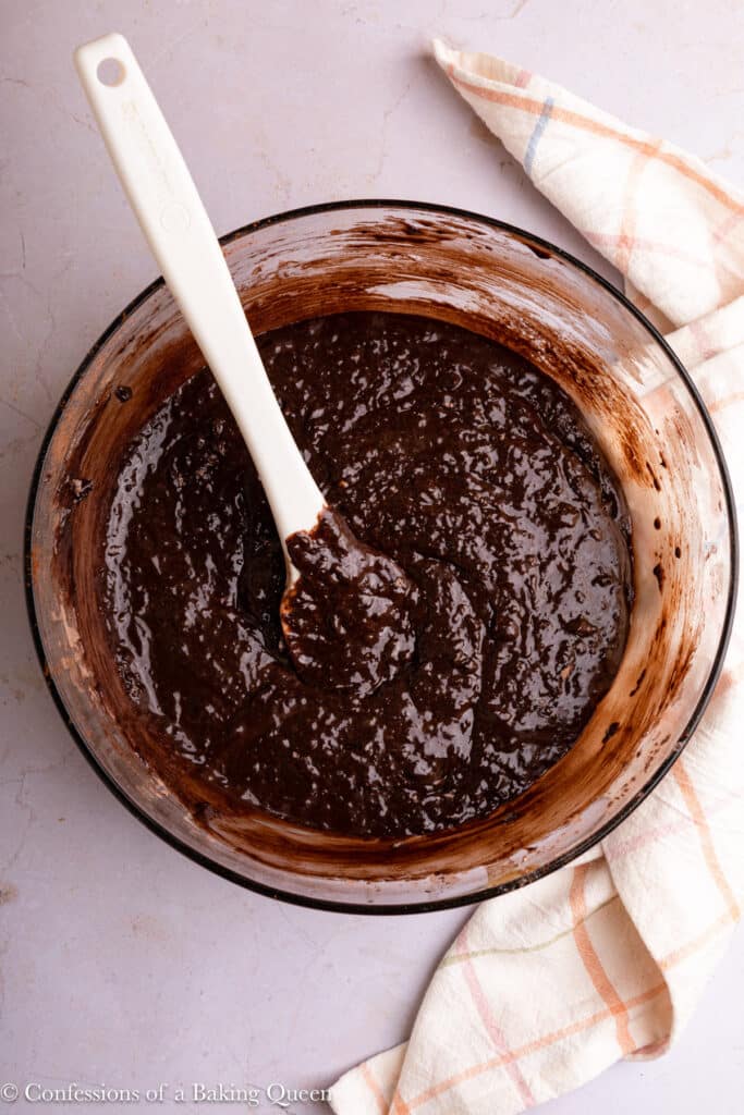 Mixing dry ingredients into wet ingredients for chocolate cake batter.