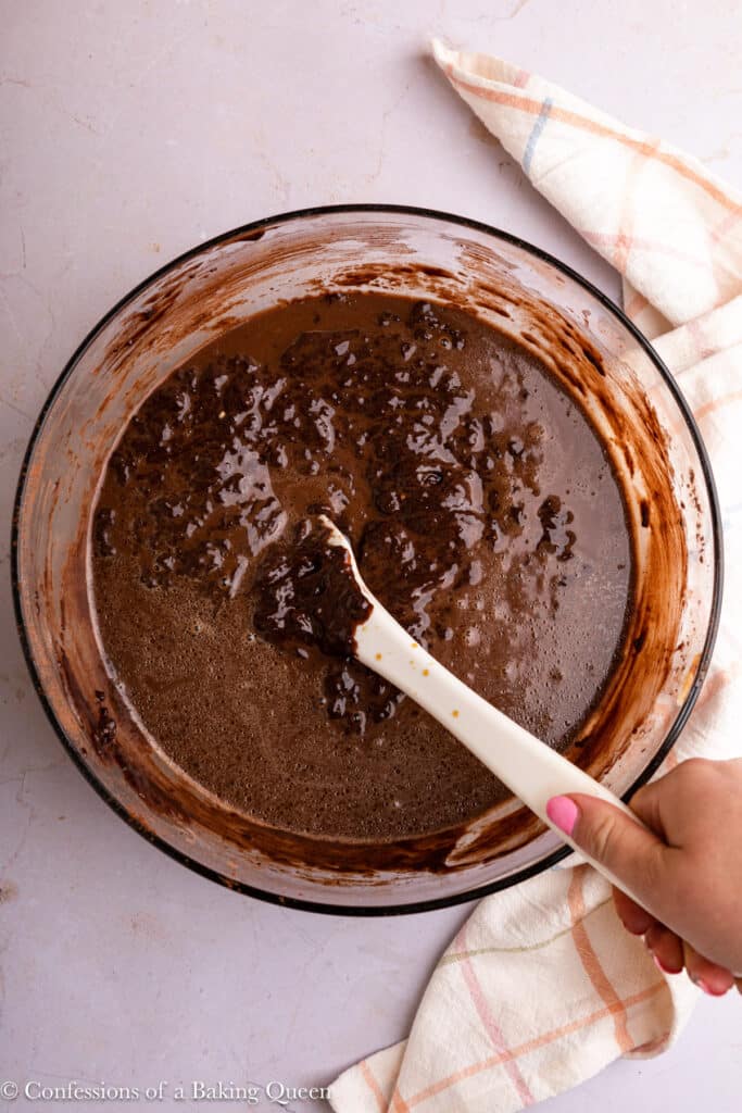 Mixing hot coffee into chocolate cake batter.