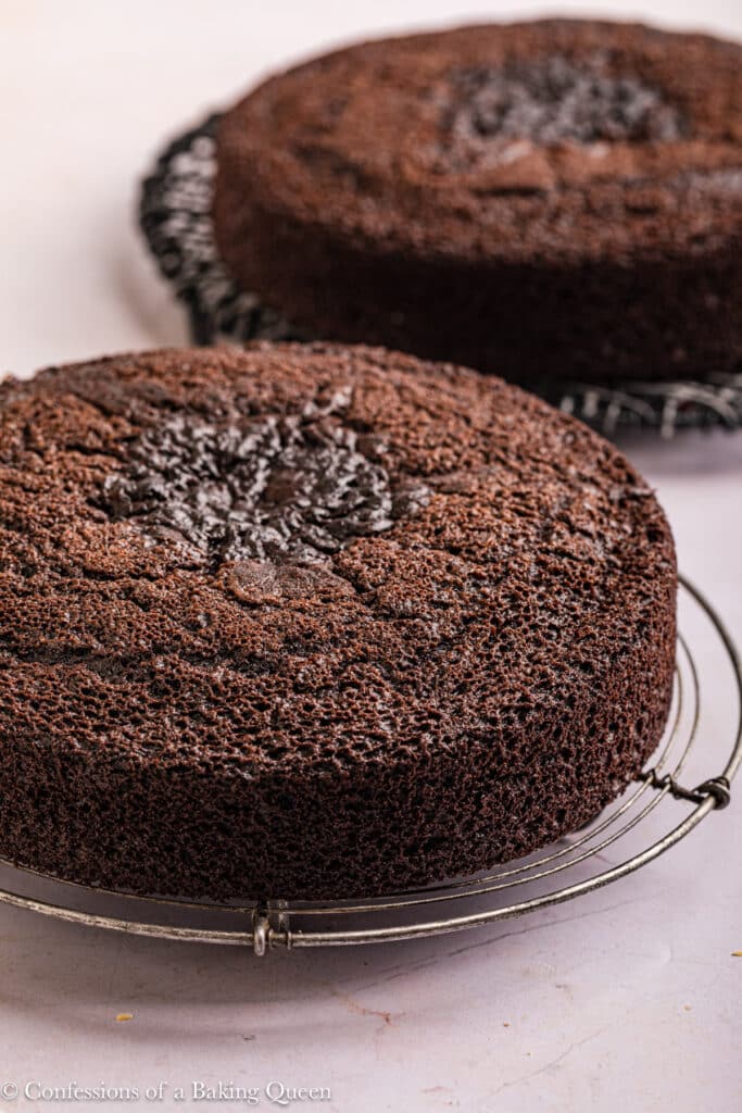 Two chocolate cakes on cooling wracks.